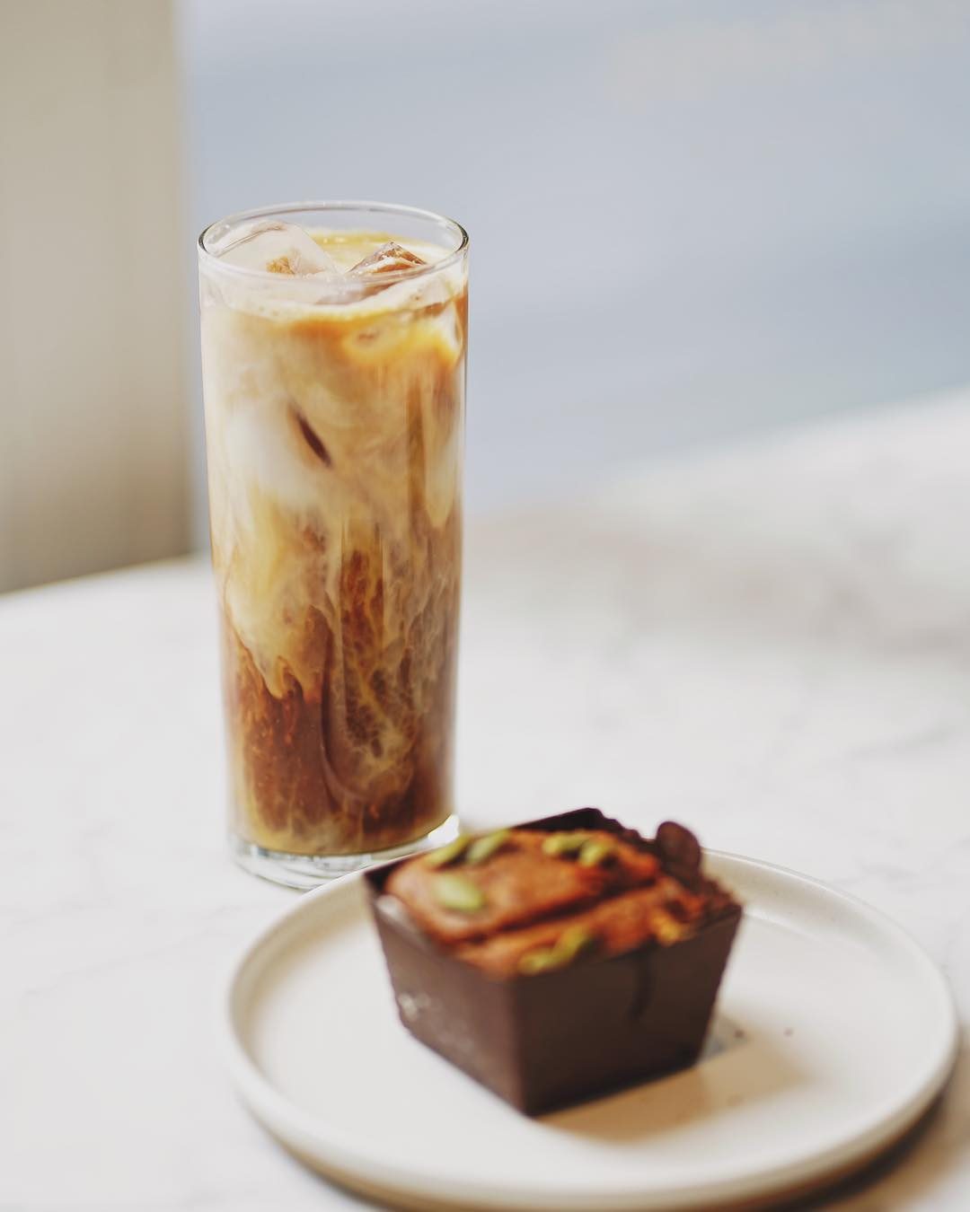 Iced latte and muffin on a cafe table